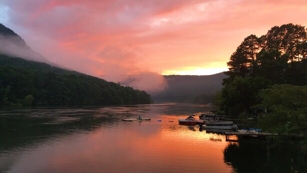 A calm river with boats docked on the right, surrounded by forested hills and a sunset sky. - Waterfront Paradise- 10 minutes from downtown Chattanooga (Chattanooga)