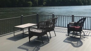 A deck with two wicker chairs and a table overlooking a lake with a forested hill in the background. - Waterfront Paradise- 10 minutes from downtown Chattanooga (Chattanooga)