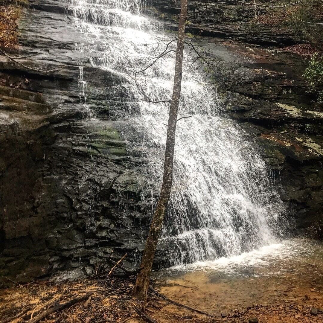 Une cascade d’eau se précipitant le long d’une falaise rocheuse.