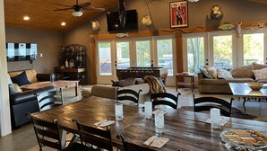 A spacious living area with a wooden ceiling, ceiling fans, a large wooden dining table, and comfortable seating. - Lake front home private dock (Paso Robles)