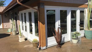 A house with a covered porch, sliding glass doors, and multiple potted cacti. - Lake front home private dock (Paso Robles)