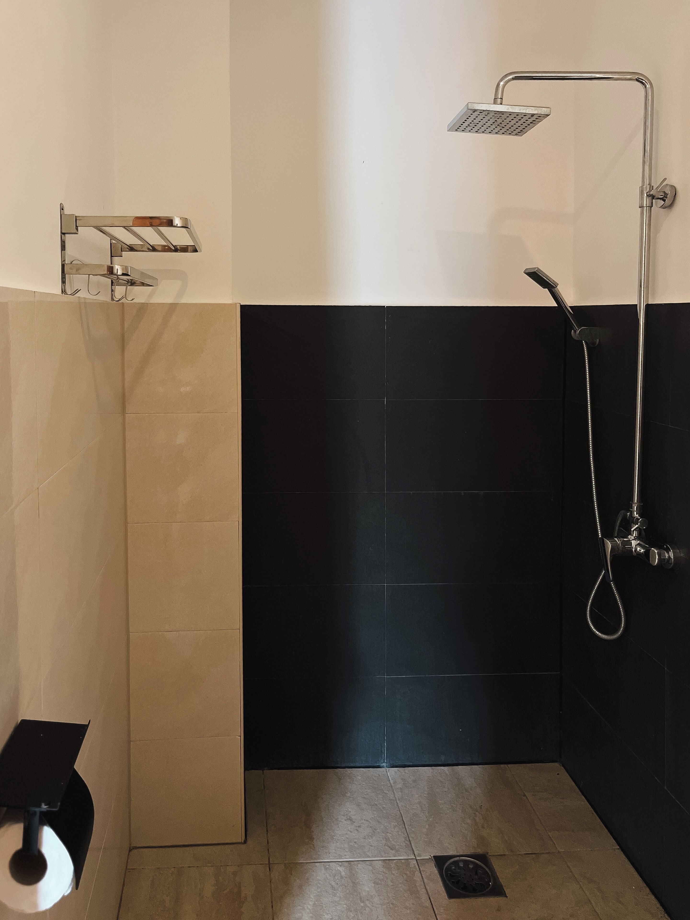 Un baño con ducha, inodoro y barra para toallas.