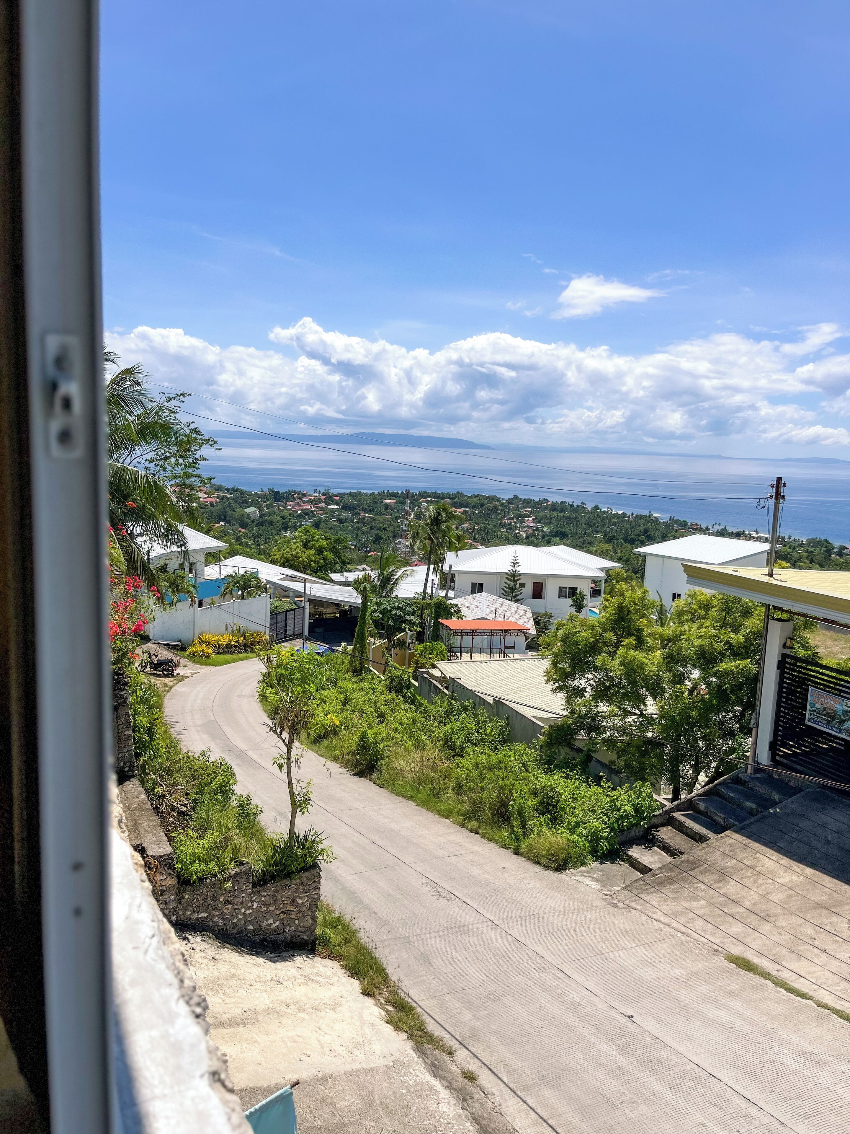 Un barrio residencial con casas, una calle curva y vistas al mar.