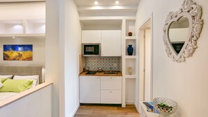 Une cuisine moderne avec des meubles blancs, un four à micro-ondes et un pare-feu en carreaux.