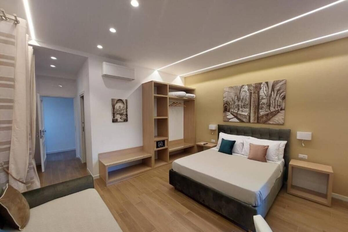 Een moderne slaapkamer met een groot bed, inbouwkasten en een schilderij aan de muur.