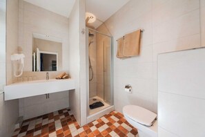 Une salle de bain avec une douche, des toilettes et un lavabo.