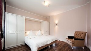 Ein Schlafzimmer mit Bett, Stuhl und Kleiderschrank.