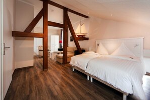 Ein Schlafzimmer mit Holzbalkendecke, einem Bett mit weißer Bettwäsche und einem Nachttisch.