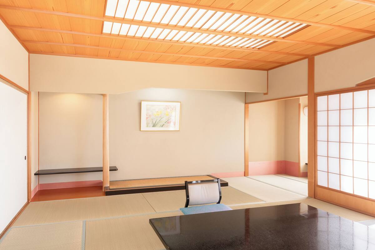 Une pièce de style japonais traditionnel, avec un sol recouvert de tatamis, une table basse et des portes coulissantes.