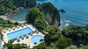 Un resort con piscina, sillas de descanso y sombrillas.