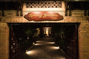 A brick pathway leading to a villa entrance with a sign reading "Spring Garden Villa".