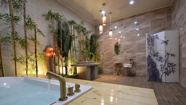 A spa area with a hot tub, bamboo wall decor, and a decorative refrigerator.