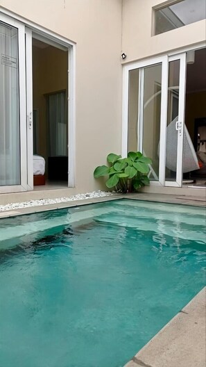 En swimmingpool med ett klart, blått vatten och en omgivande poolterrass av betong.