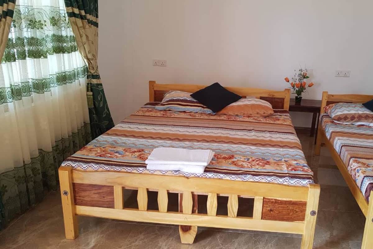 Una habitación con dos camas de madera, cada una con ropa de cama y almohadas estampadas.