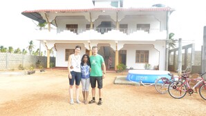 A two-story building with a balcony, a swimming pool, and bicycles parked outside. - Nilaveli Star View Hotel (Nilaveli)