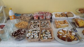 A buffet table with various food items including pastries, sandwiches, and beverages. - Hotel Frida (Rimini)