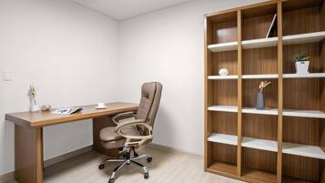 Una oficina moderna con un escritorio de madera, una silla de oficina y una estantería empotrada.