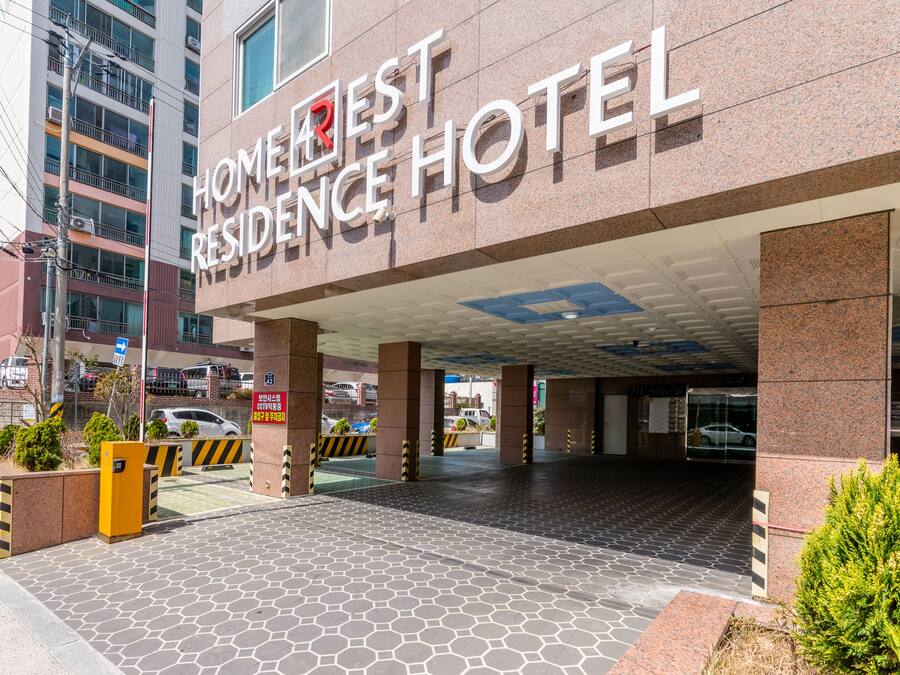 Entrada de un hotel con un letrero que dice "HOME RESIDENCE HOTEL".