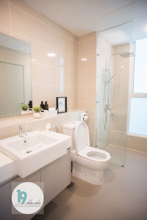 A modern bathroom with two sinks, a toilet, and a glass-enclosed shower.