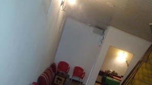 A room with a staircase, a dining area, and several red and grey chairs. - Nature Mount Pavilion Ella (Ella)