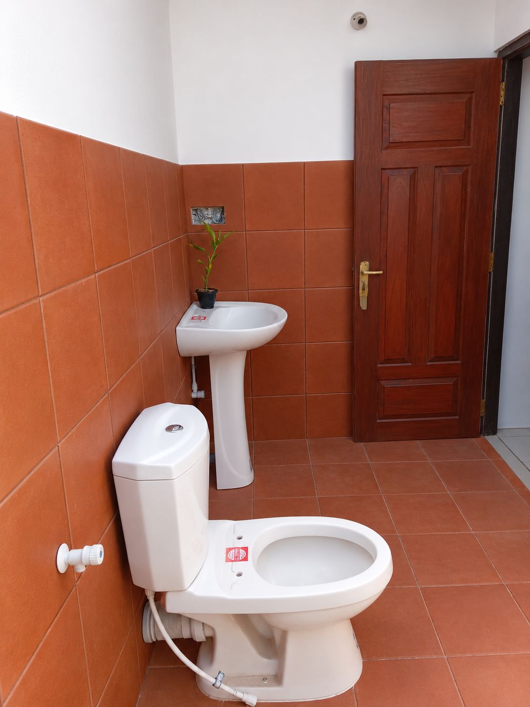 A bathroom with a toilet, a sink, and a door.