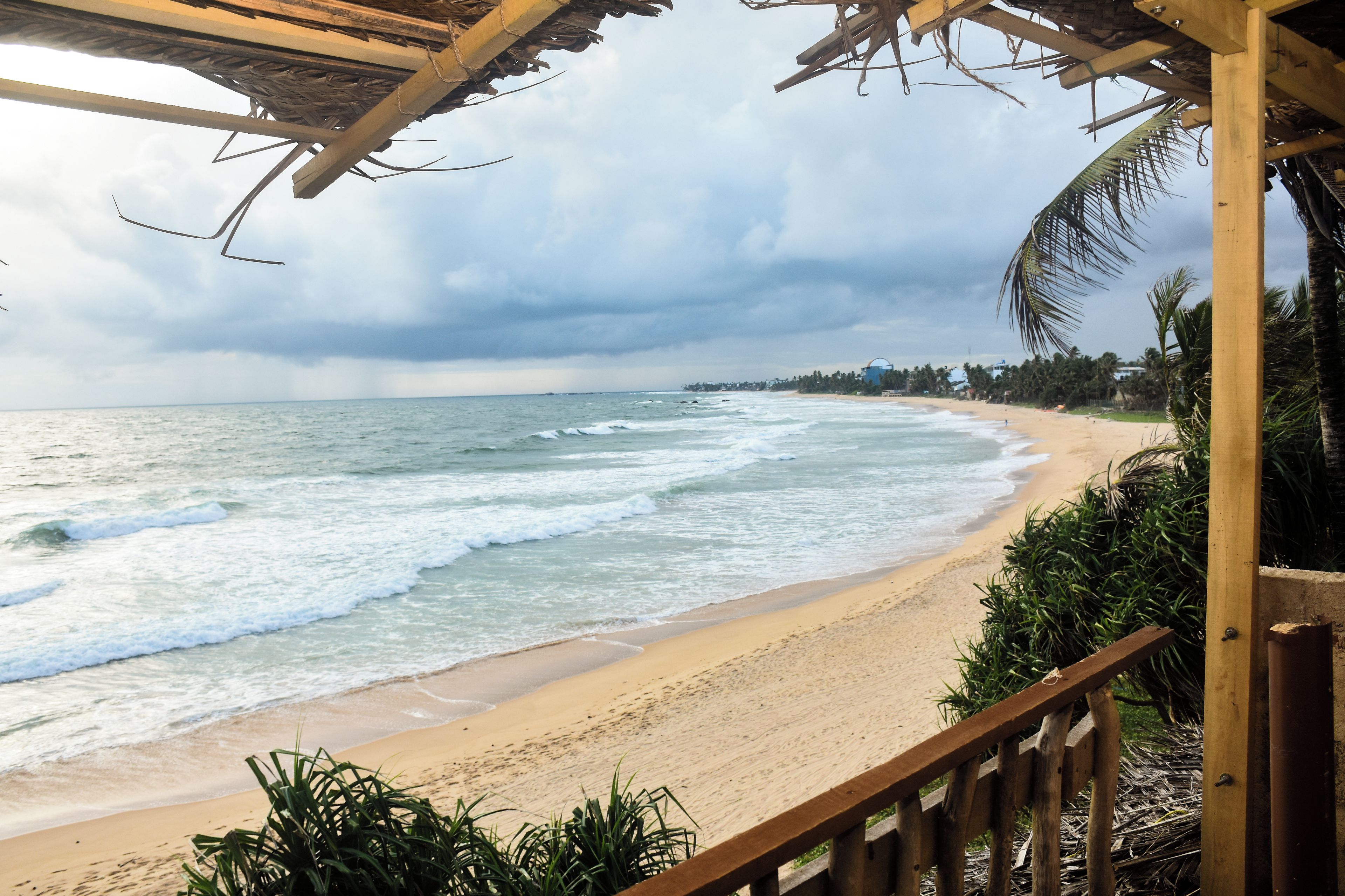 A beach with a wooden structure overlooking the ocean.