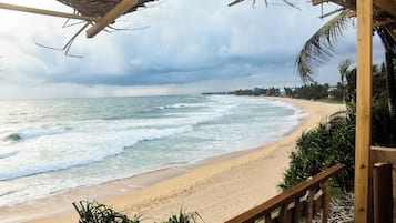 A beach with a wooden structure overlooking the ocean.