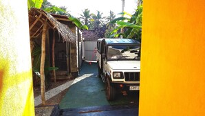 A narrow alleyway with a parked vehicle and a small structure on the left. - villa crocodile beach (Hikkaduwa)
