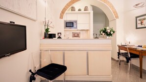 Una cocina moderna con microondas, lavamanos y encimera. Hay un comedor con mesa y sillas.