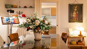 A dining table with a vase of flowers, a laptop, and a lamp. -  Rome center Campo de Fiori great reviews within walking distance to everything! (Roma)