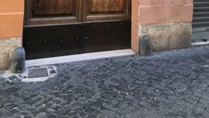A large wooden double door with a metal handle, set in an arched doorway, leading to a building with a sign indicating "CONDOMINIO 10". -  Rome center Campo de Fiori great reviews within walking distance to everything! (Roma)