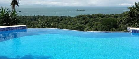 Piscine extérieure, piscine à débordement, parasols de plage
