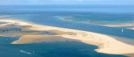 An aerial view of a coastal area with sandy beaches and clear blue waters.