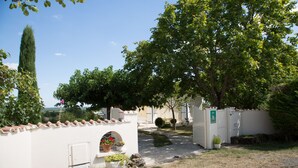 A courtyard with a stone pathway, white walls, and potted plants. - House with all mod cons, covered and shared pool - quiet and green setting (Loubers)