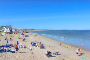 A beach with beach chairs and umbrellas, a house, and a clear sky. - Downsticks (Saco)