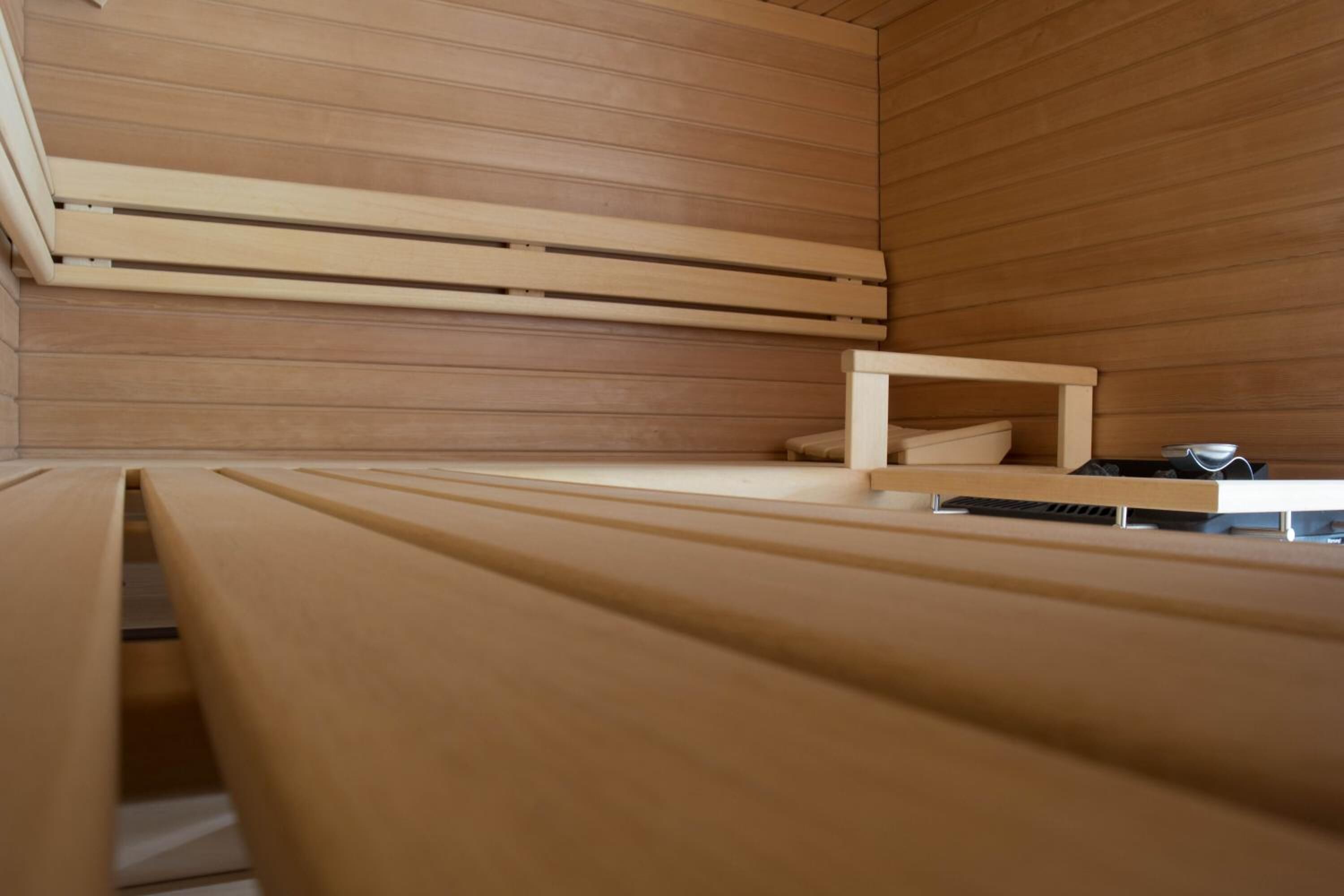 A modern, minimalist room with wooden paneling and a bench.