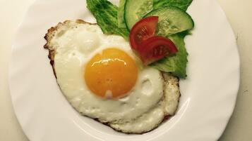 A plate with a fried egg, lettuce, and tomato slices.