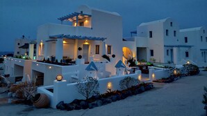 A modern white building with multiple balconies and outdoor lighting. - Santoxenia Luxury Villa (Santorini)