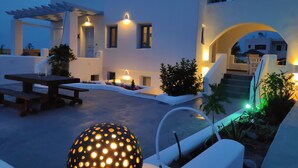 A modern outdoor area with a pool, seating, and a pergola. - Santoxenia Luxury Villa (Santorini)