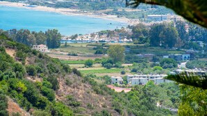 A coastal view with buildings, a beach, and greenery. - Harma Rooms & Apartments (Apokoronas)