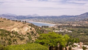 A coastal landscape with a view of the sea, hills, and a town in the distance. - Harma Rooms & Apartments (Apokoronas)