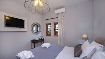 Habitación de hotel con cama, televisión, escritorio y lámpara.