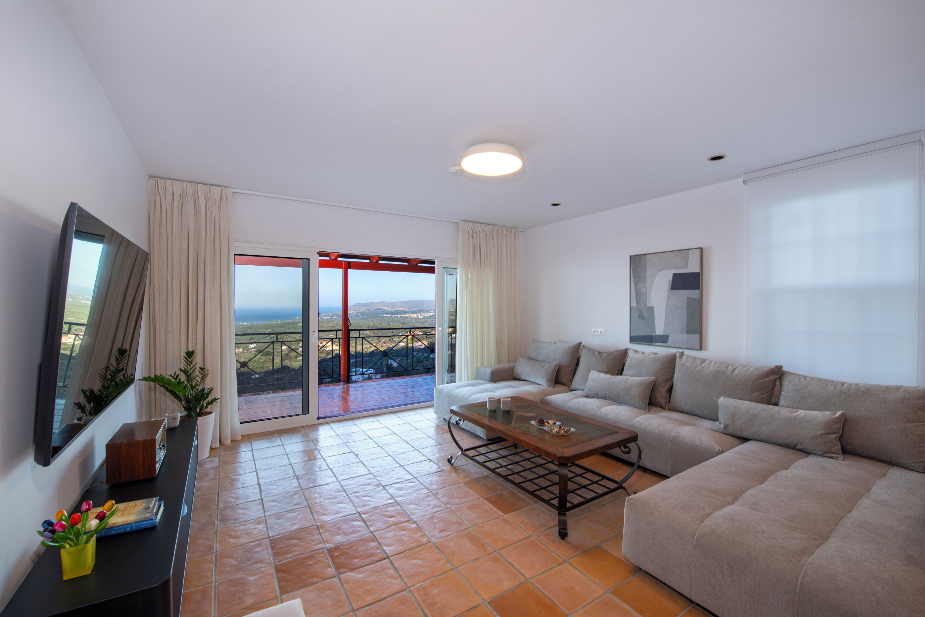 Un salon moderne avec un canapé, une table basse et un balcon offrant une vue agréable.