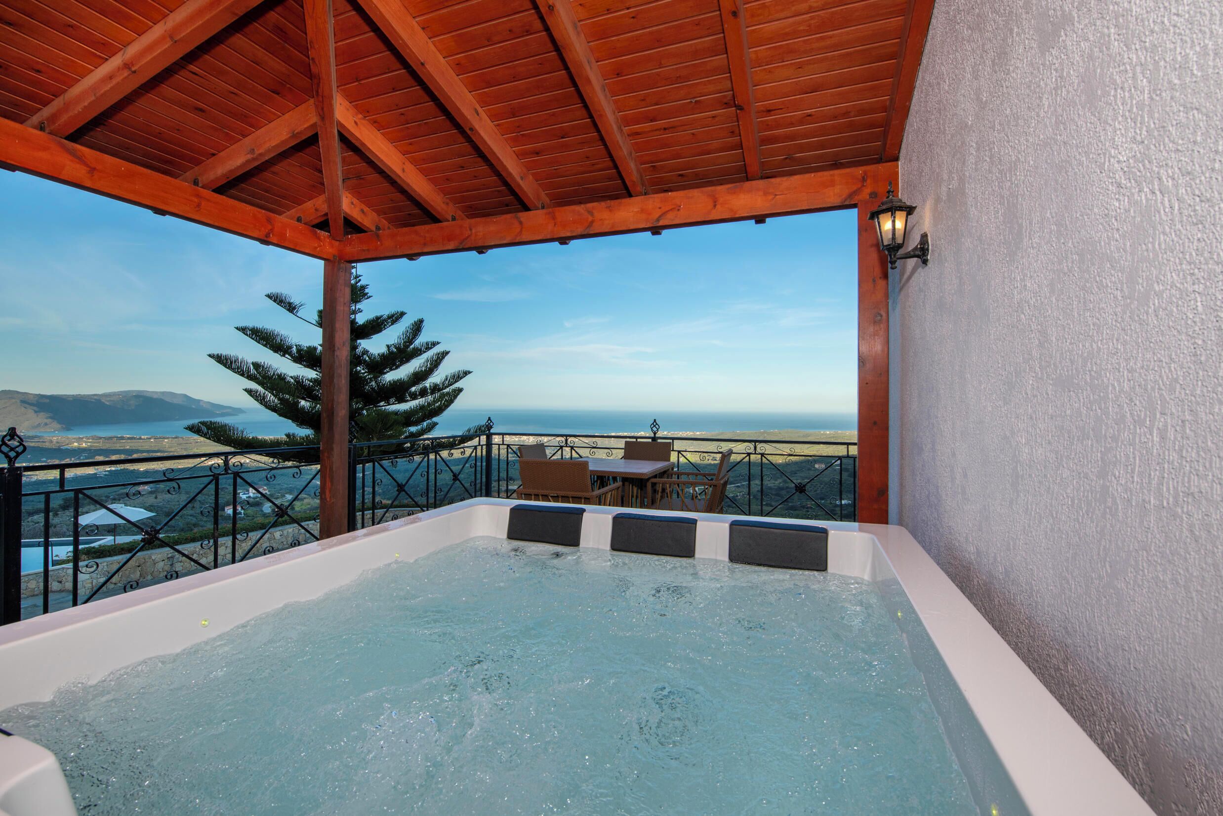 A hot tub with a view of the beach and mountains.