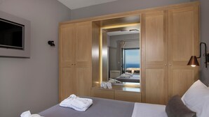 A hotel room with a bed, a large wardrobe, a mirror, and a television. - Thea Villas Complex (Apokoronas)