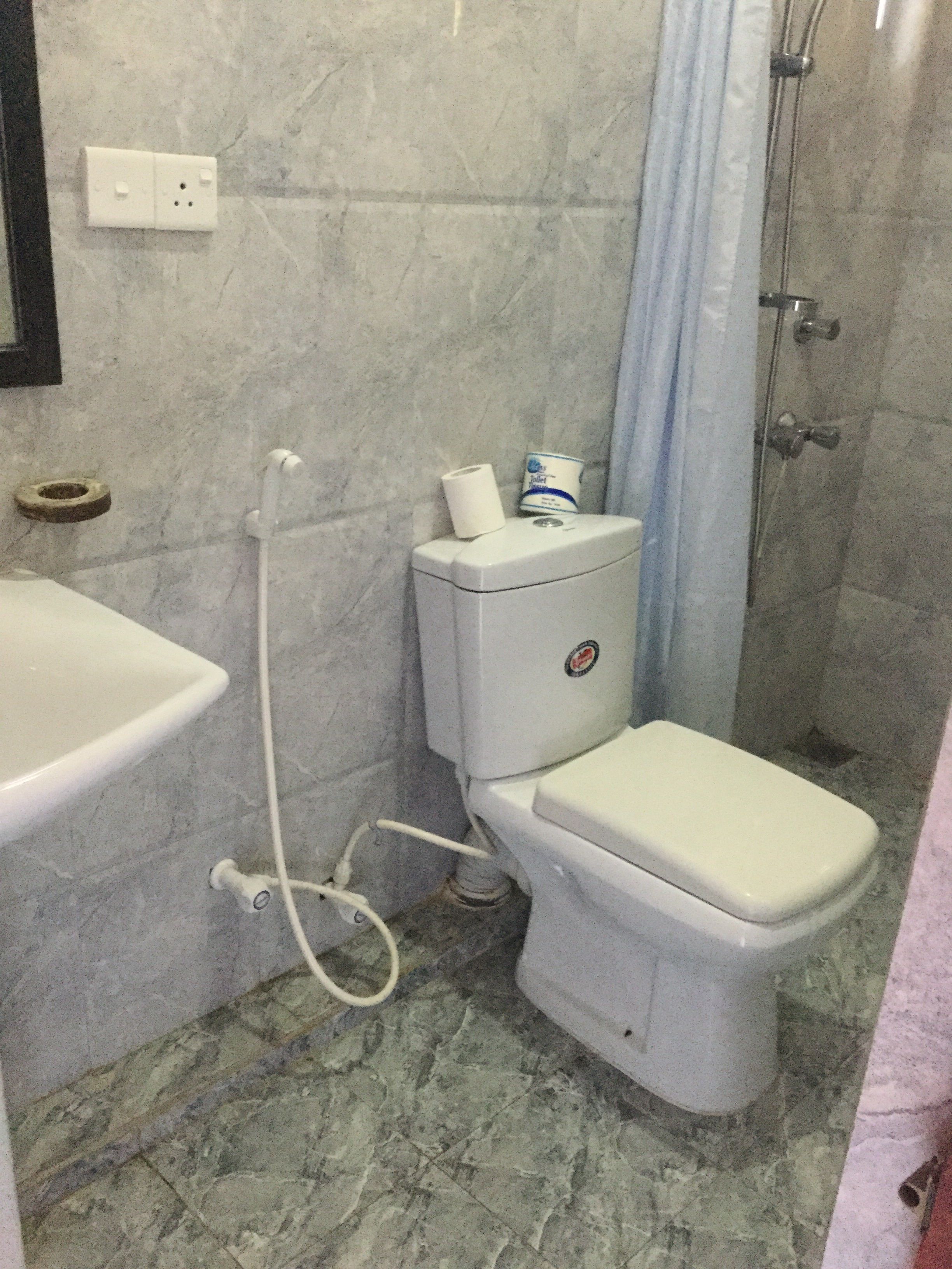 Une salle de bain avec des toilettes, un lavabo et une douche.