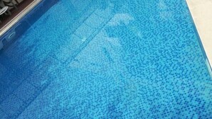 Une piscine dont le fond est recouvert de carreaux.