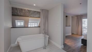 A modern bathroom with a freestanding bathtub, a shower, and a large mirror.