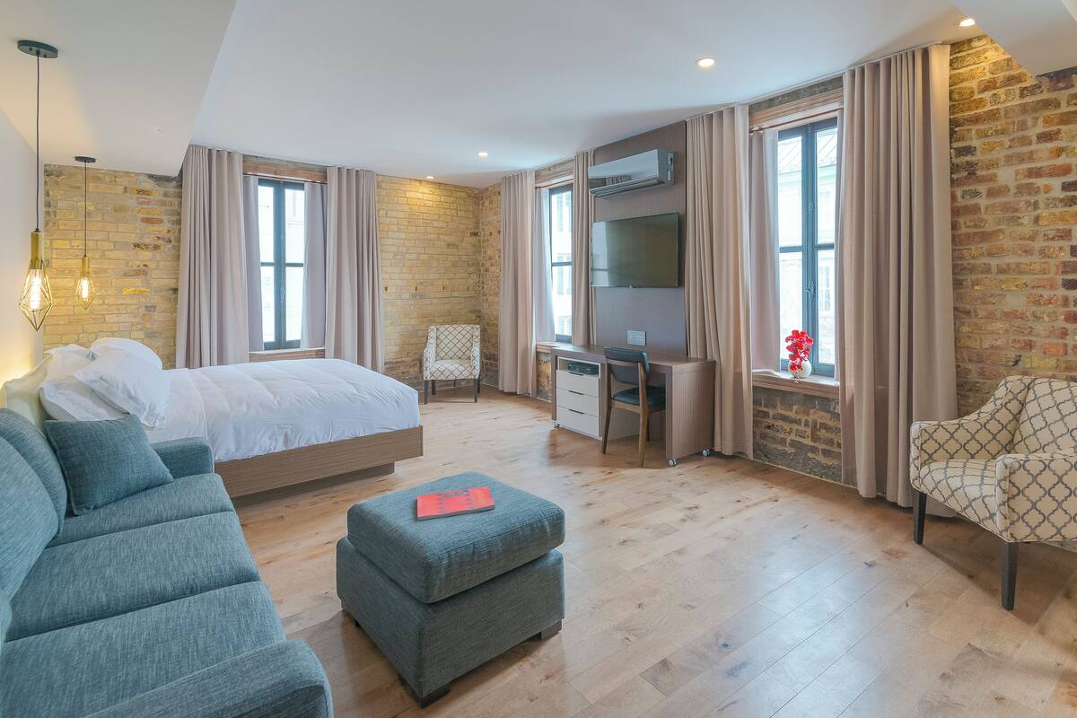 Un dormitorio moderno con una cama grande, un escritorio, una silla y un televisor.