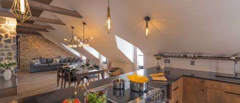 Una cocina moderna con una isla central, comedor y sala de estar.